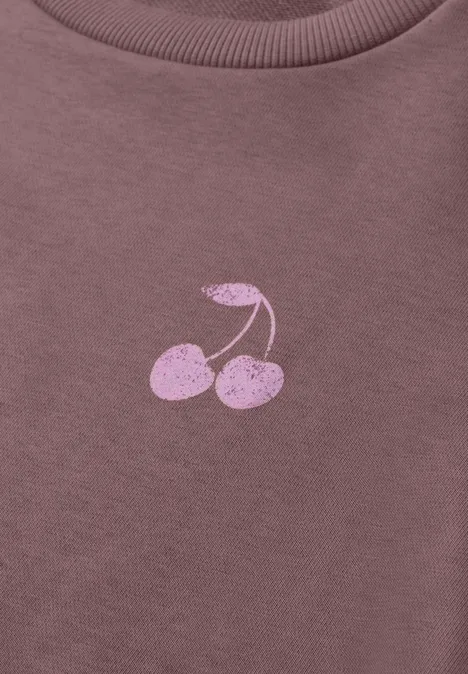 Gros plan d'un t-shirt violet avec impression de cerises roses
