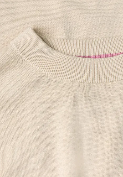 Beiger Pullover mit Rundhalsausschnitt, feine Strickstruktur sichtbar.