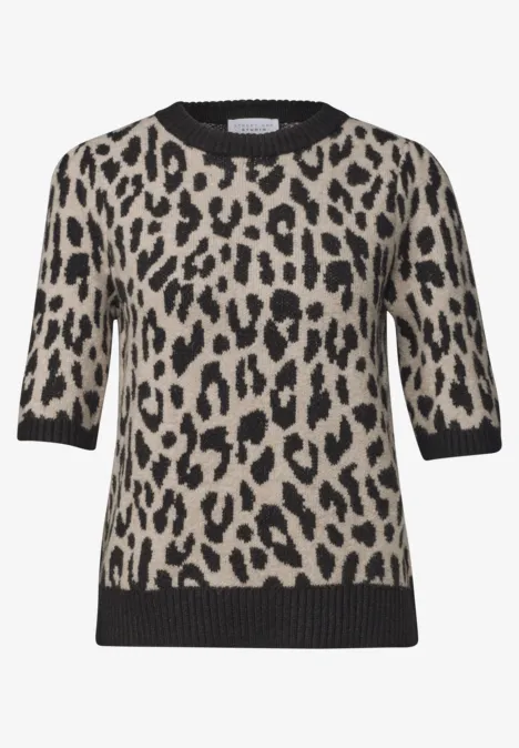 Beiges, kurzärmeliges Strickshirt mit schwarzem Leopardenflecken-Muster und kontrastierenden schwarzen Abschlüssen.