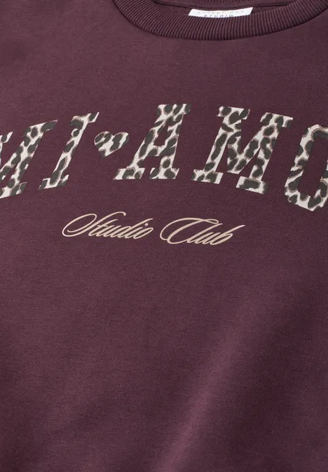 Bordeauxrotes Sweatshirt mit Animal-Print-Schriftzug und ‚Studio Club‘-Logo in Gold.