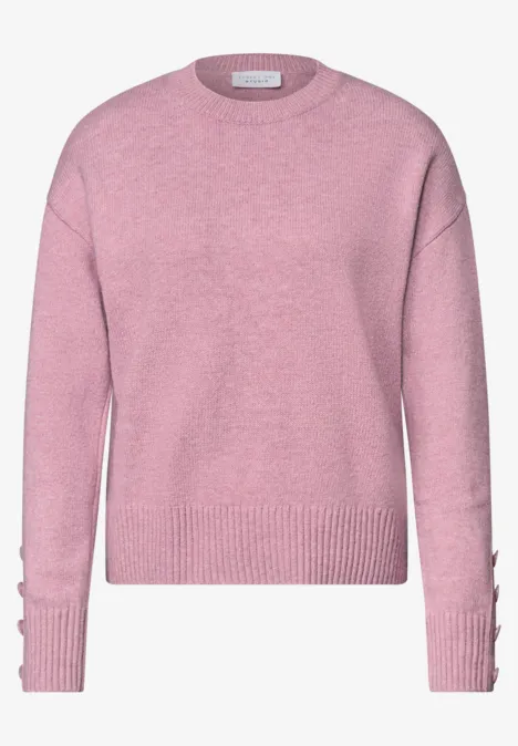 Rosa Strickpullover mit Rundhalsausschnitt, langen Ärmeln, Rippenmuster und Knopfdetails an den Ärmeln.