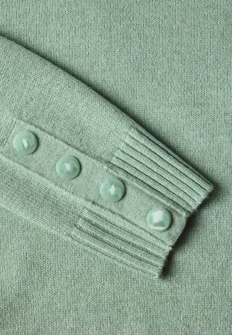 Pullover mit Rundhals und Knopfdetails grayed mint mel. Grüner Strickpulloverärmel mit vier Knöpfen und geripptem Bündchen.