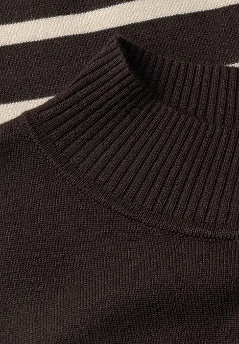 Sweter z golfem i w paski charred brown Zbliżenie czarnego golfu z prążkowanym splotem na czarno-białym, paskowanym tle.