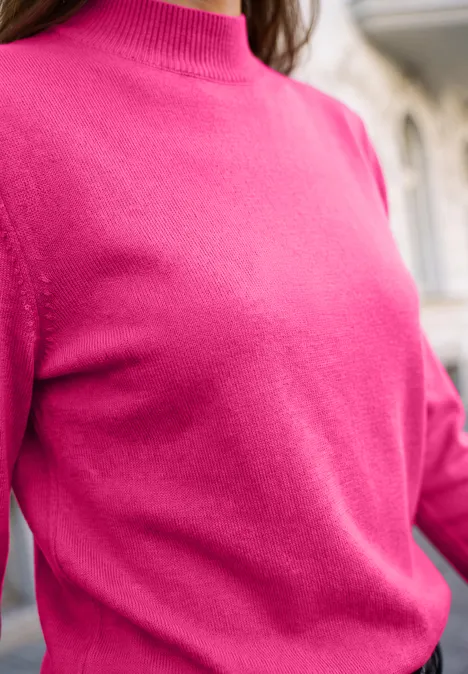 Sweter z długim rękawem i golfem ruby raspberry Zbliżenie na intensywnie różowy sweter noszony przez osobę