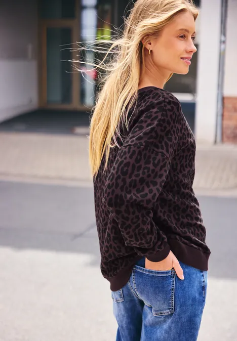 Sweatshirt met ronde hals in een Loose Fit-pasvorm very berry Jonge blonde vrouw in luipaardprinttrui en spijkerbroek maakt wandeling buiten.