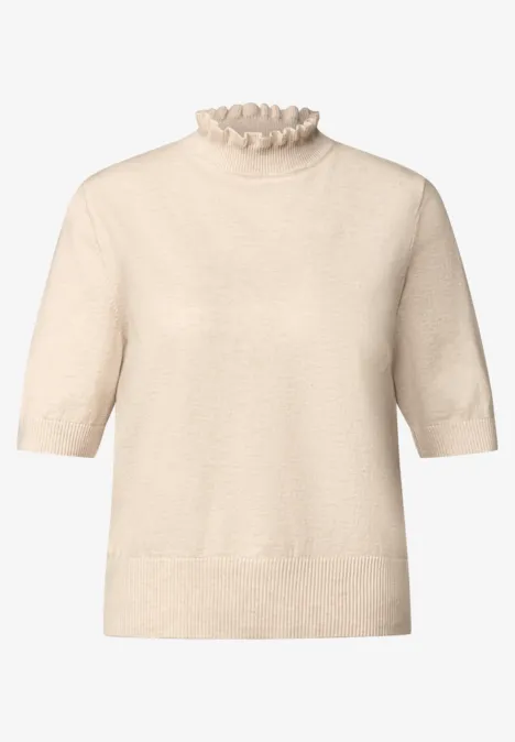Pull à manches courtes beige clair avec col volanté et coupe légèrement cintrée.