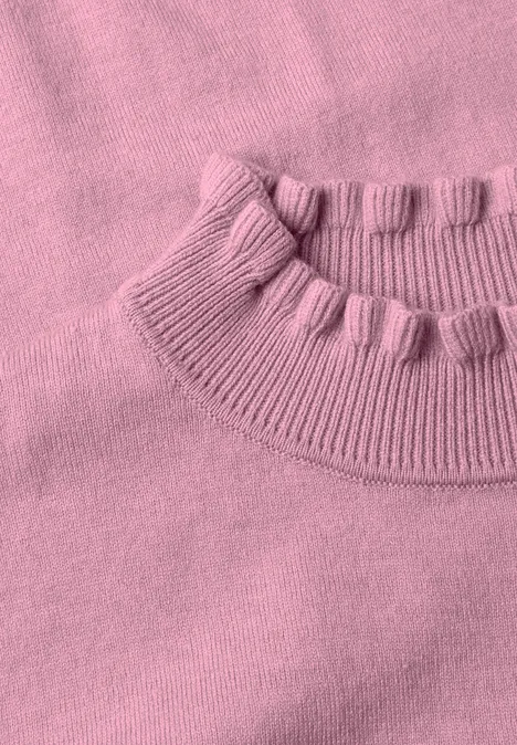 Różowy sweter z dzianiny z prążkowanym okrągłym dekoltem i małymi pomponami