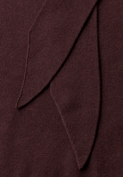 Close-up van een donkerrode gebreide stof met overlappende flapjes.