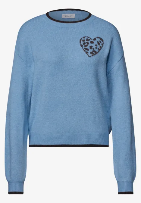 Leicht blauer Pullover mit schwarzem Bund an Ärmeln und Kragen und Herz mit Leopardenmuster auf der Brust.