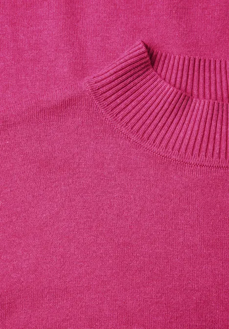 Ein pinkfarbener, schlichter Pullover mit Rundhalsausschnitt.