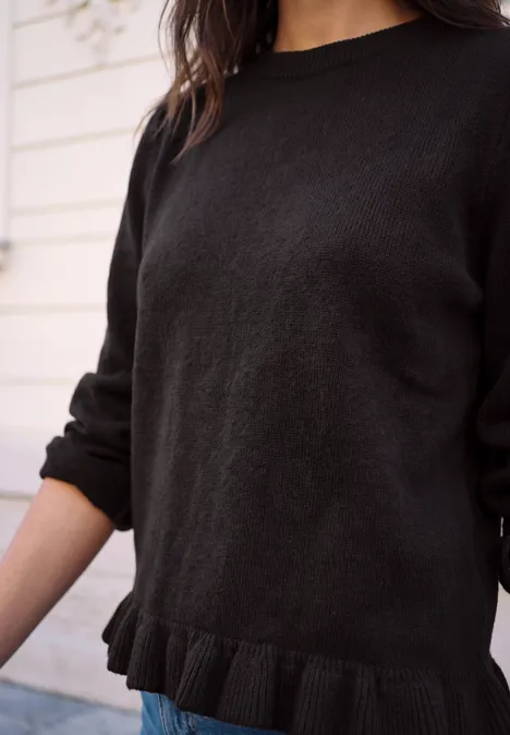 Pullover mit Rundhals und Rüschen am Saum charred brown Schwarzer Strickpullover mit Rüschen am Saum, getragen von Frau in heller Umgebung.
