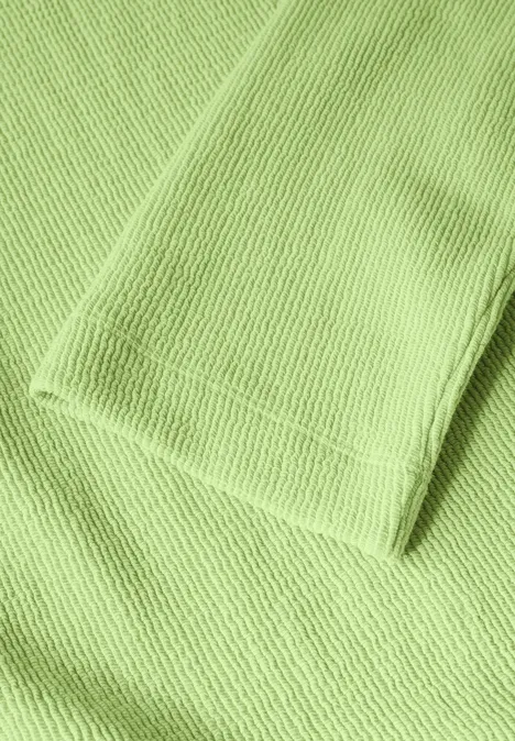 Tissu côtelé vert clair à texture visible.