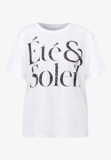 Ein weißes T-Shirt mit auffälligem schwarzen Schriftzug 'Été & Soleil' auf der Vorderseite.