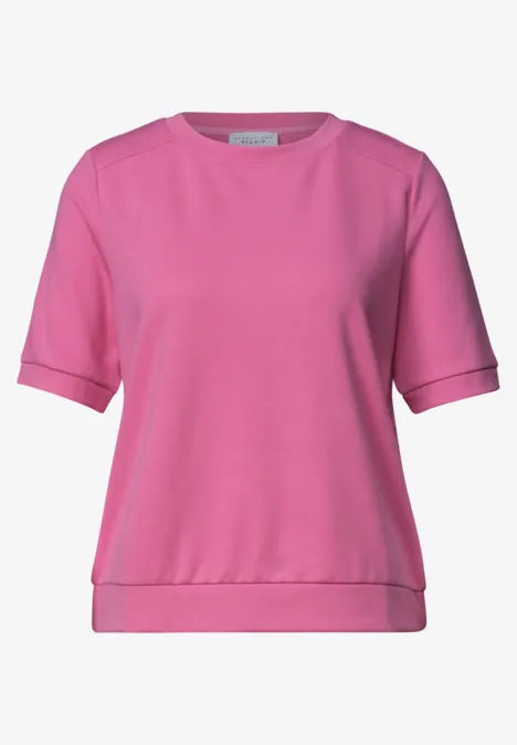 Een roze T-shirt met korte mouwen en ronde hals.