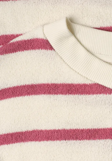 Nahaufnahme eines cremefarbenen Pullovers mit pinken Streifen und geripptem Rundhalsausschnitt.