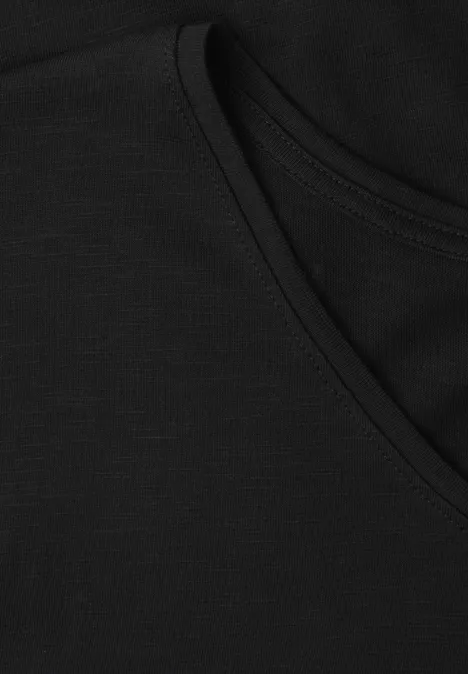 Nahaufnahme eines schwarzen Baumwoll-T-Shirts mit Rundhalsausschnitt und Nahtdetail.