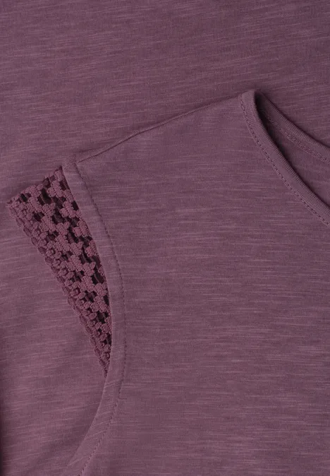 Close-up van een mouwloos paars topje met fijn kantinzet bij de schouder.