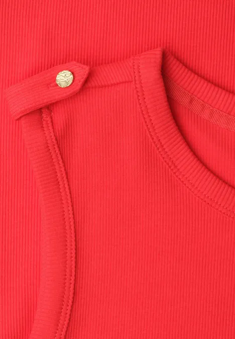 Close-up van rood geribbeld textiel met een goudkleurige knoop op de schouder