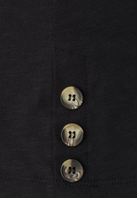 Nahaufnahme von drei grauen Knöpfen auf schwarzem Stoff.