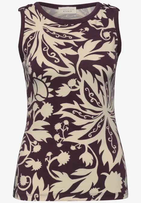 Mouwloos topje met crème bloem- en bladprint op een donkere achtergrond.