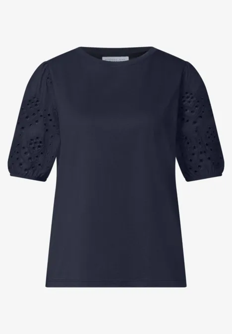 Dunkelblaue Bluse mit kurzen, leicht gepufften Ärmeln und Lochstickerei-Details.