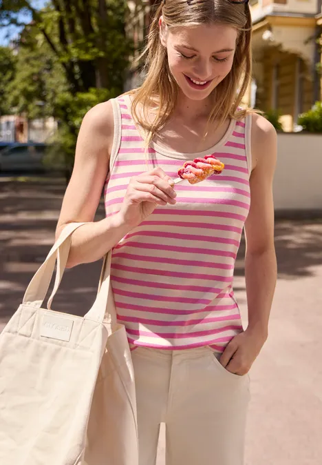Top mit Rundhals und Rippstruktur simply pink Frau in rosa-weiß gestreiftem Top hält im Freien einen pinken Lutscher, trägt helle Hose und Stofftasche.
