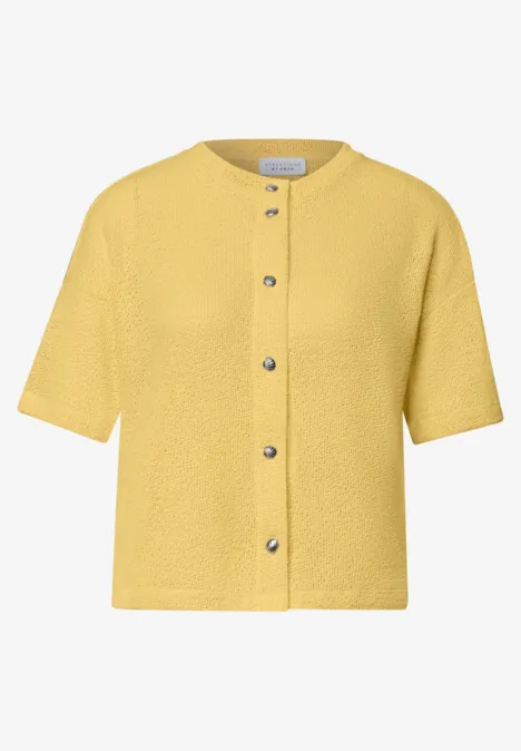 Gelbe, kurzärmlige Strickjacke mit Knopfleiste und Rundhalsausschnitt im kastigen Schnitt.