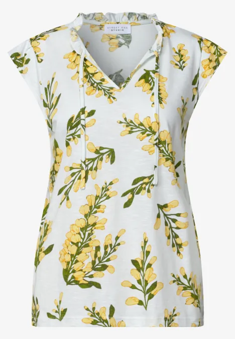 Wit damesvest zonder mouwen met V-hals en gele bloemenprint.