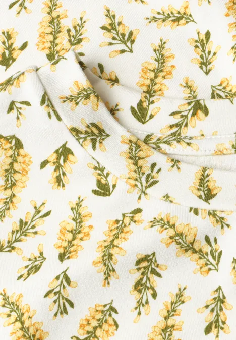 Weiße Oberfläche mit gelben Blüten und grünen Blättern in wiederholtem Muster