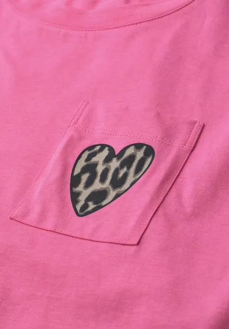 Nahaufnahme eines rosa T-Shirts mit einer Brusttasche, darauf ein Herz in Leopardenmuster.