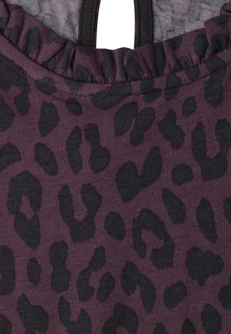 Top met ronde hals en ruches very berry Close-up van een bordeaux stof met zwart luipaardprint en ruffle bij de halslijn.