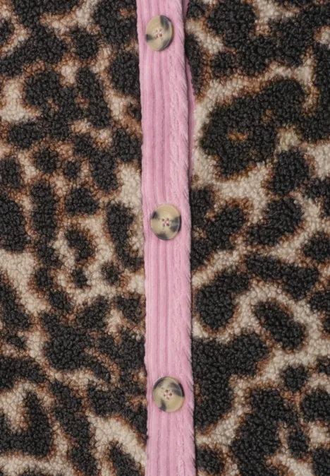 Nahaufnahme eines Stoffes mit Leopardenmuster, rosa Ziernaht und runden Holzknöpfen.