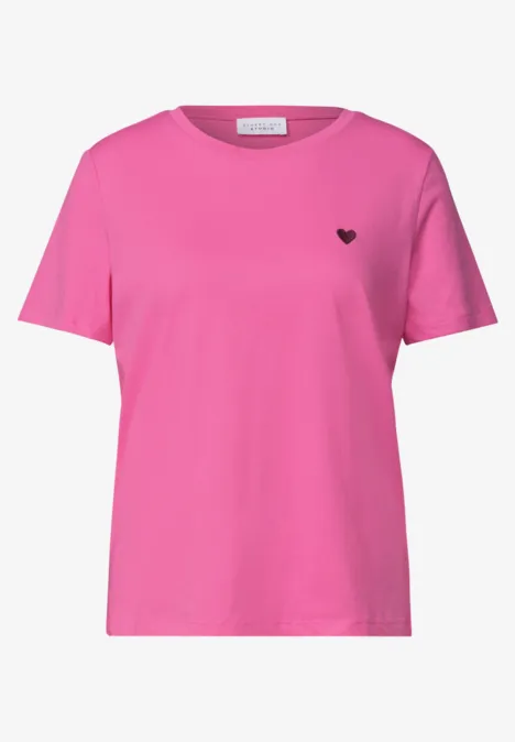 Schlichtes pinkes T-Shirt mit kurzen Ärmeln und kleinem schwarzem Herzlogo auf der Brust.