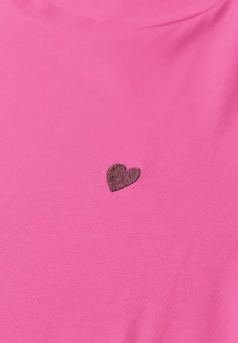 Ein pinkes T-Shirt mit einem kleinen, zentrierten Herz.