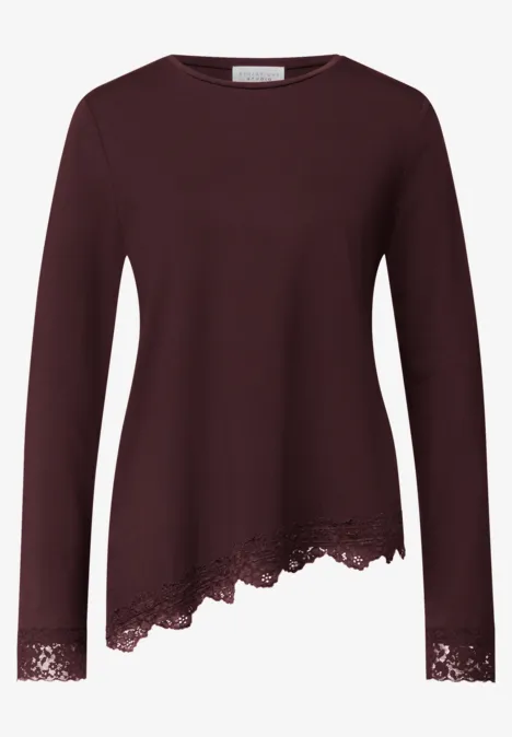 Donkerrood damesshirt met lange mouwen, asymmetrische zoom en kanten afwerking onderaan en bij de mouwen.