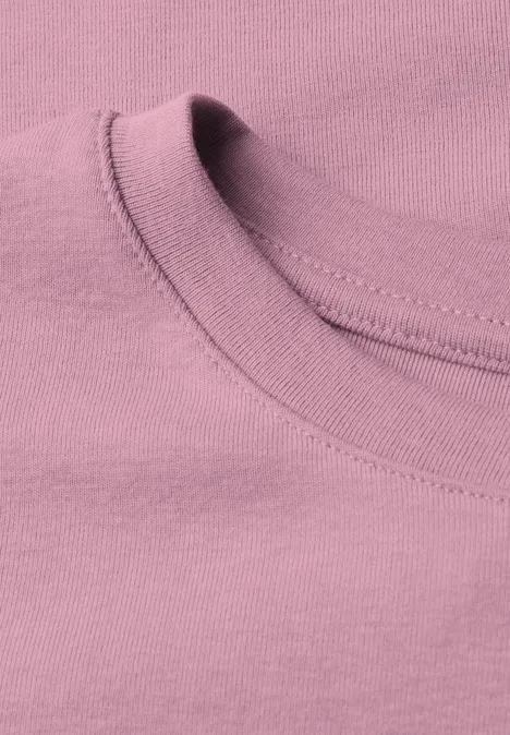 Nahaufnahme eines rosa T-Shirt-Ausschnitts mit geripptem Kragen.