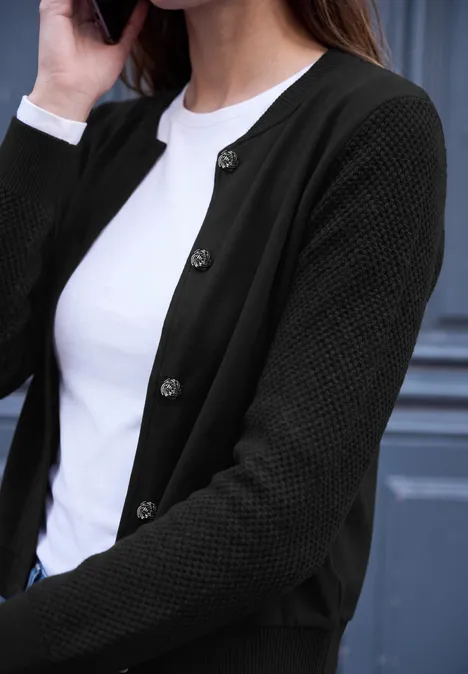 Vrouw in zwarte gebreide cardigan en wit T-shirt belt.