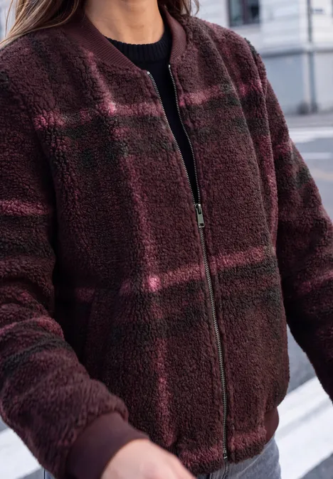 Nahaufnahme einer burgunderroten Teddy-Fleece-Bomberjacke mit Reißverschluss.
