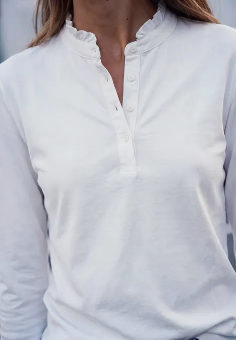 Langarm Shirt mit Rundhals und Rüschen off white Person trägt weißes, langärmeliges Henley-Shirt mit Stehkragen und Knopfleiste.