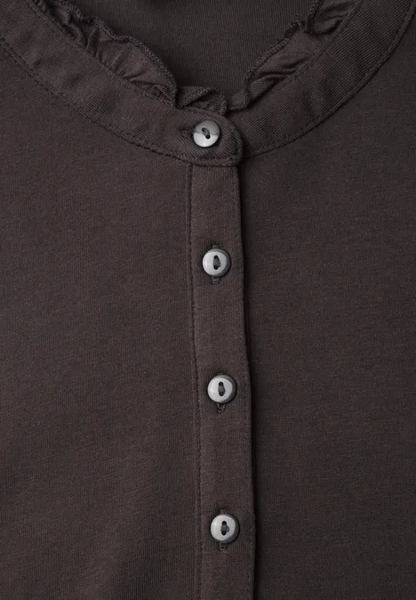 Langarm Shirt mit Rundhals und Rüschen charred brown Nahaufnahme eines braunen Oberteils mit Rüschen am Kragen und fünf grauen Knöpfen.
