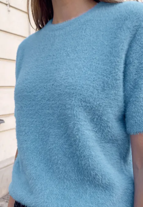 T-shirt douillet à l'aspect tricoté loom blue Personne porte un pull court à manches courtes bleu clair et duveteux.
