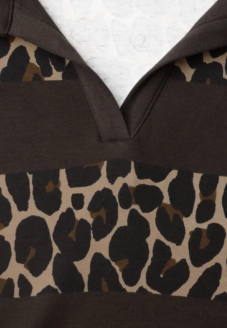Gros plan sur un pull à capuche marron avec motif léopard et encolure en V.