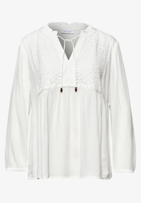 Witte, luchtige, geborduurde boho-blouse met V-hals, koordsluiting en lange mouwen.