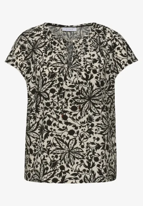 Dames T-shirt met korte mouwen, zwart bloemenpatroon op een lichte achtergrond.