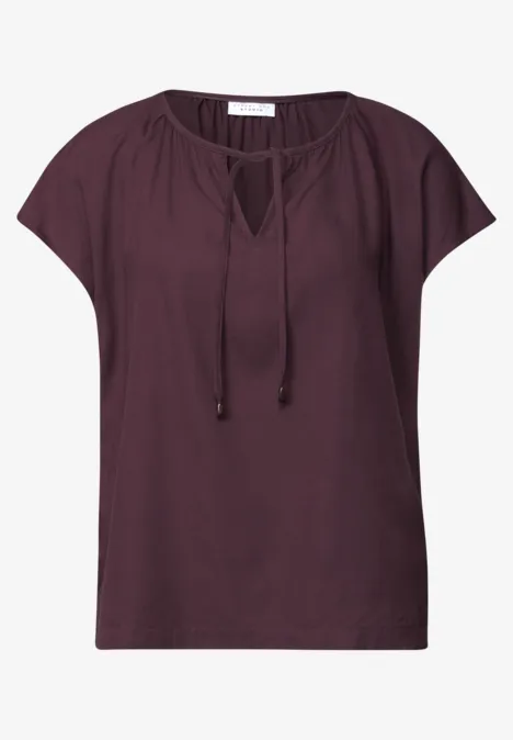 Dunkles pflaumenfarbenes Damen-Shirt mit legerem Schnitt, kurzen Ärmeln und Tunnelzug am V-Ausschnitt.