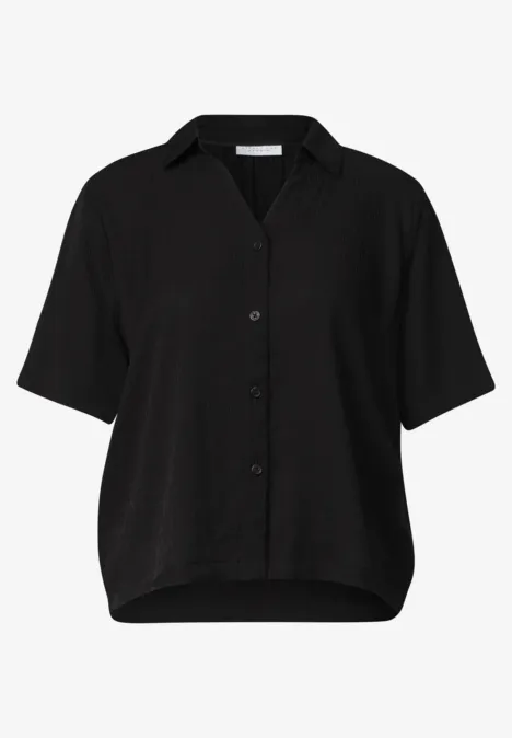 Schwarze Bluse mit Knopfleiste, kurzen Ärmeln und Hemdkragen.