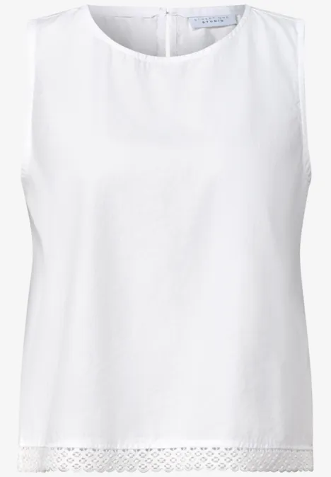 Weiße ärmellose Bluse mit Rundhalsausschnitt und feiner Spitze am Saum.