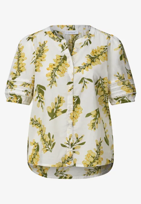 Witte blouse met geel bloemmotief en groene bladeren, korte mouwen, losse pasvorm.