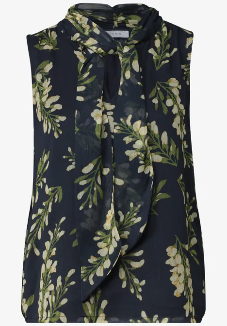 Dunkelblaue ärmellose Bluse mit grünem Blattmuster und Schleifenkragen.