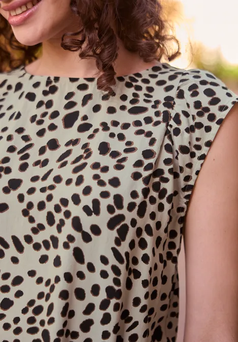 Blouse met afhangende schouders en luipaardprint Black Close-up van een glimlachende vrouw in een mouwloze jurk met vlekkenpatroon.